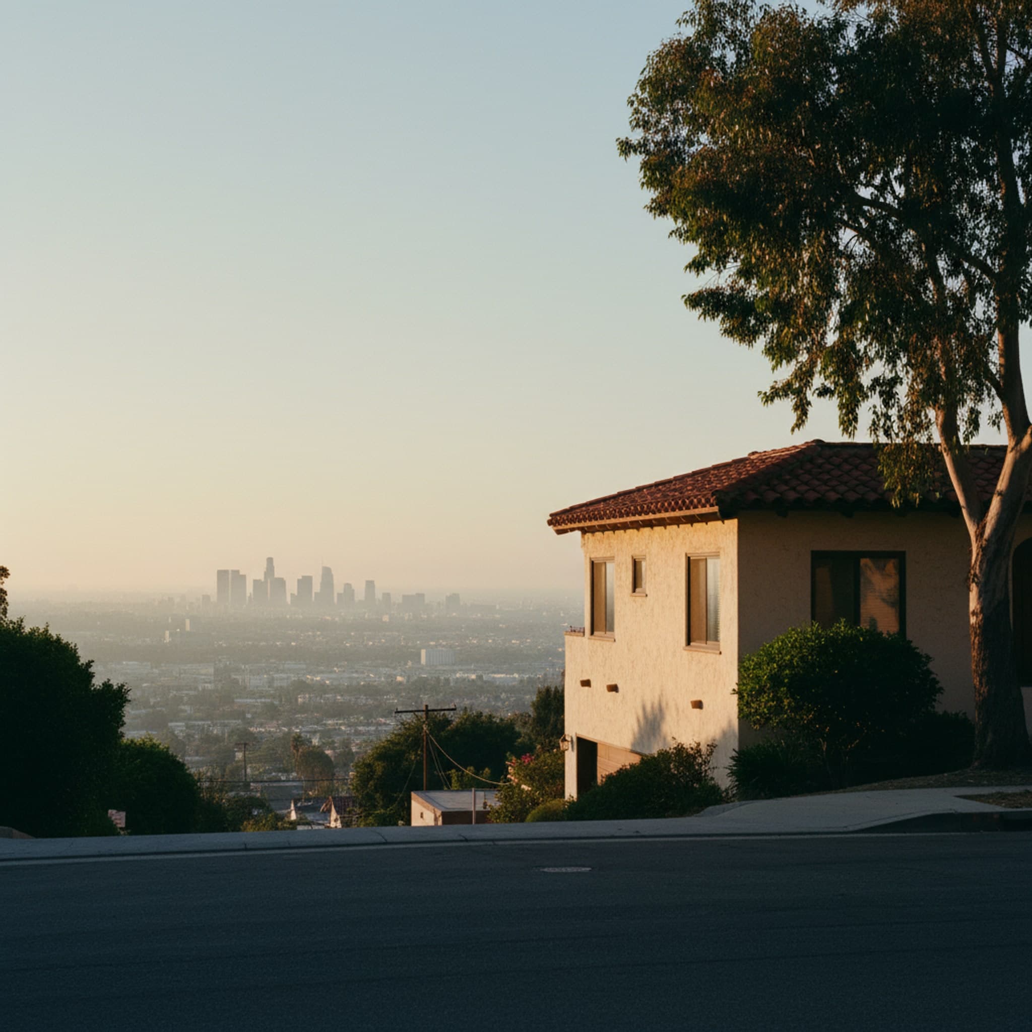 Los Angeles, CA — The Hollywood sign caught from a quiet residential street in Beachwood Canyon at the moment the last warm light hits the letters, telephone wires cutting across the foreground in dark silhouette, no tourists, no helicopters, just the everyday residential angle a local actually sees.