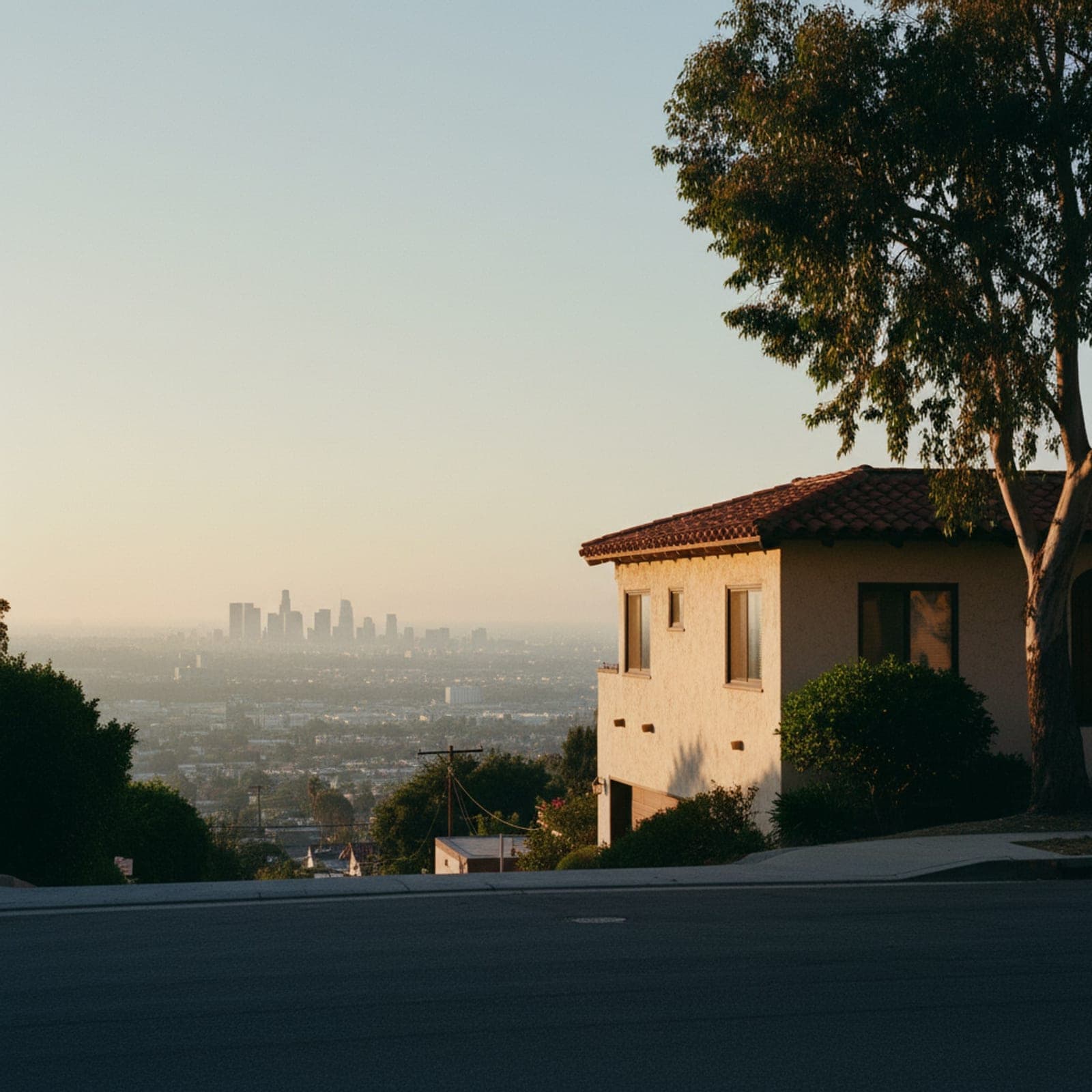 Los Angeles, CA — The Hollywood sign caught from a quiet residential street in Beachwood Canyon at the moment the last warm light hits the letters, telephone wires cutting across the foreground in dark silhouette, no tourists, no helicopters, just the everyday residential angle a local actually sees.