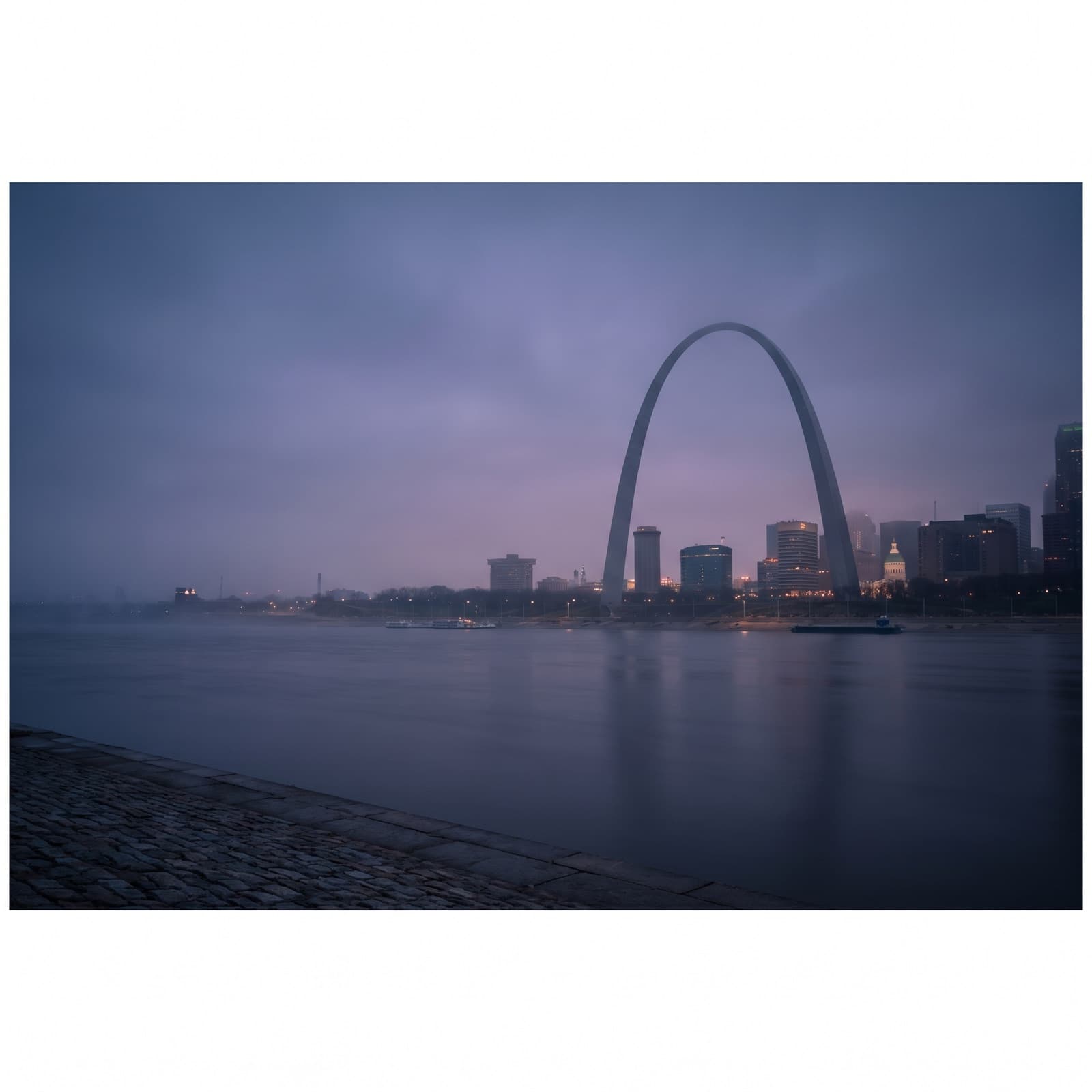 St. Louis, MO — Gateway Arch over the Mississippi riverfront at dusk